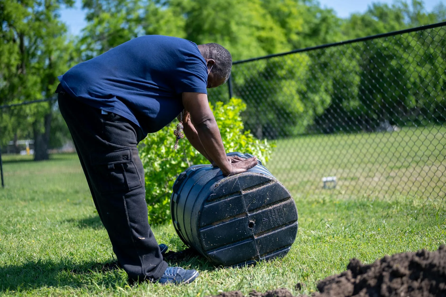 Black compost tumbler in a garden for fast composting