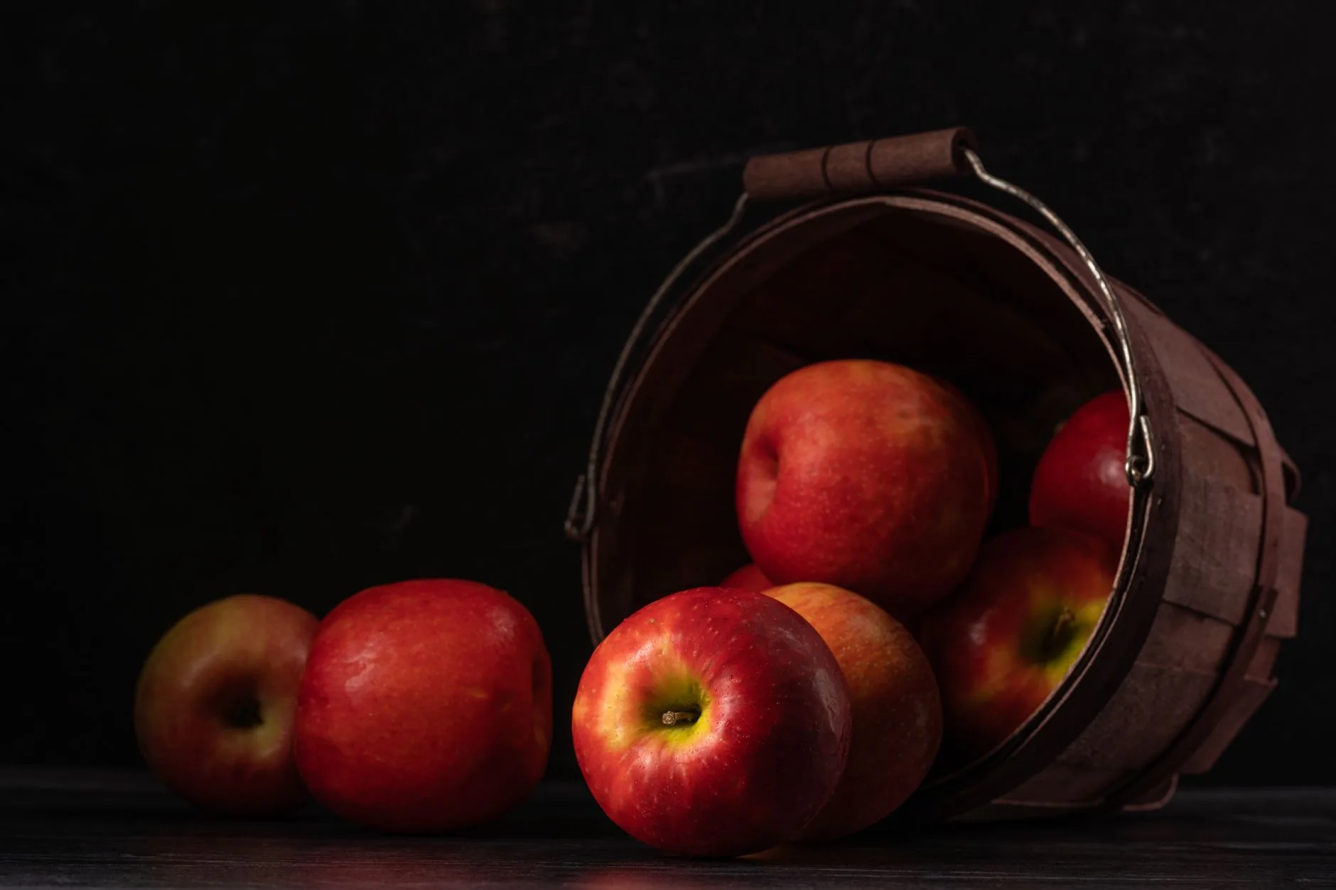 Different red apple varieties in a wooden basket