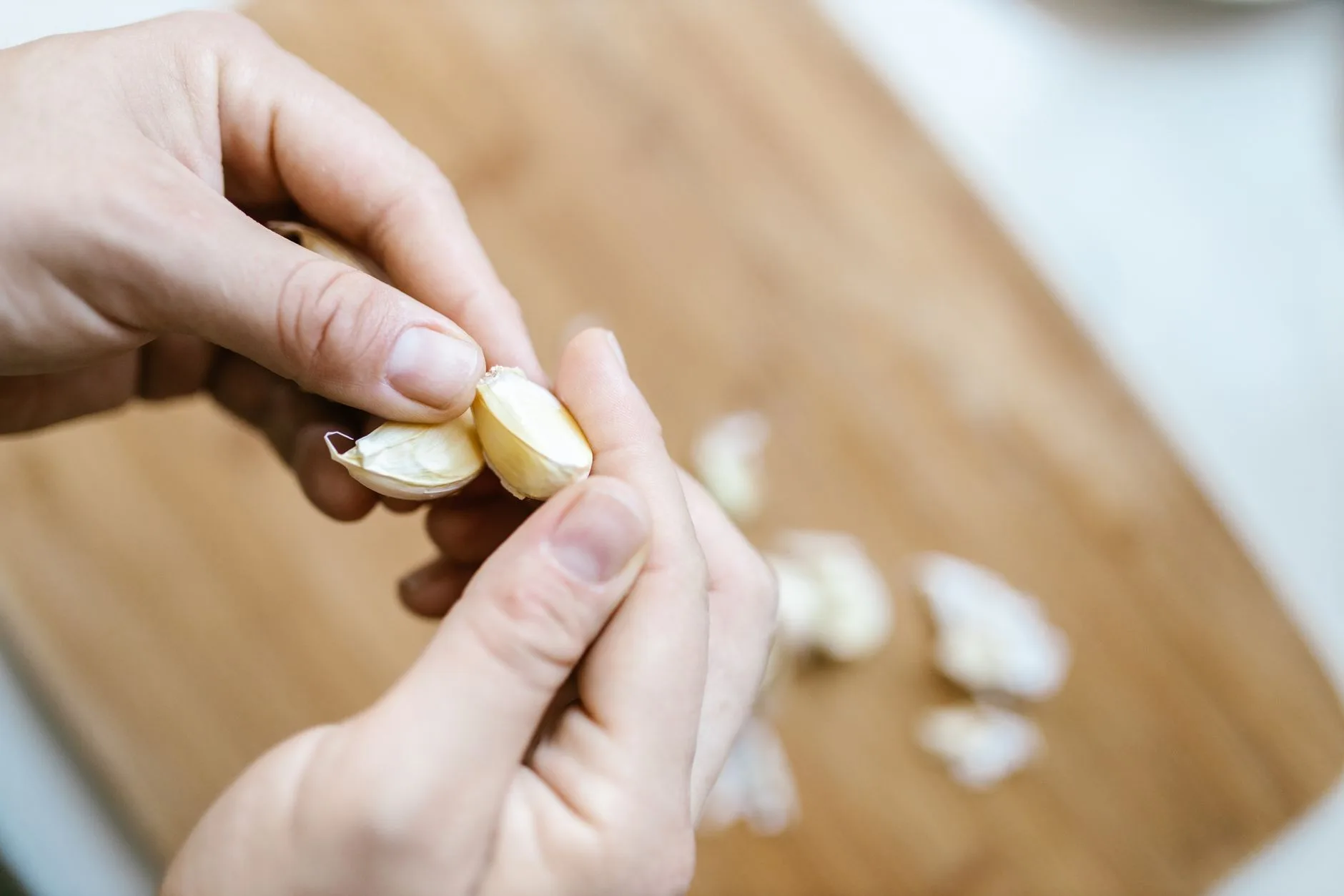 Hands separating garlic cloves ready for planting